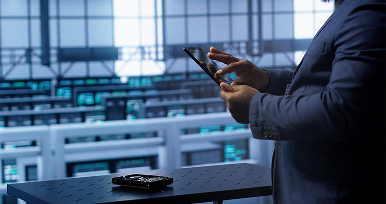 Person using tablet in a server room network facility.